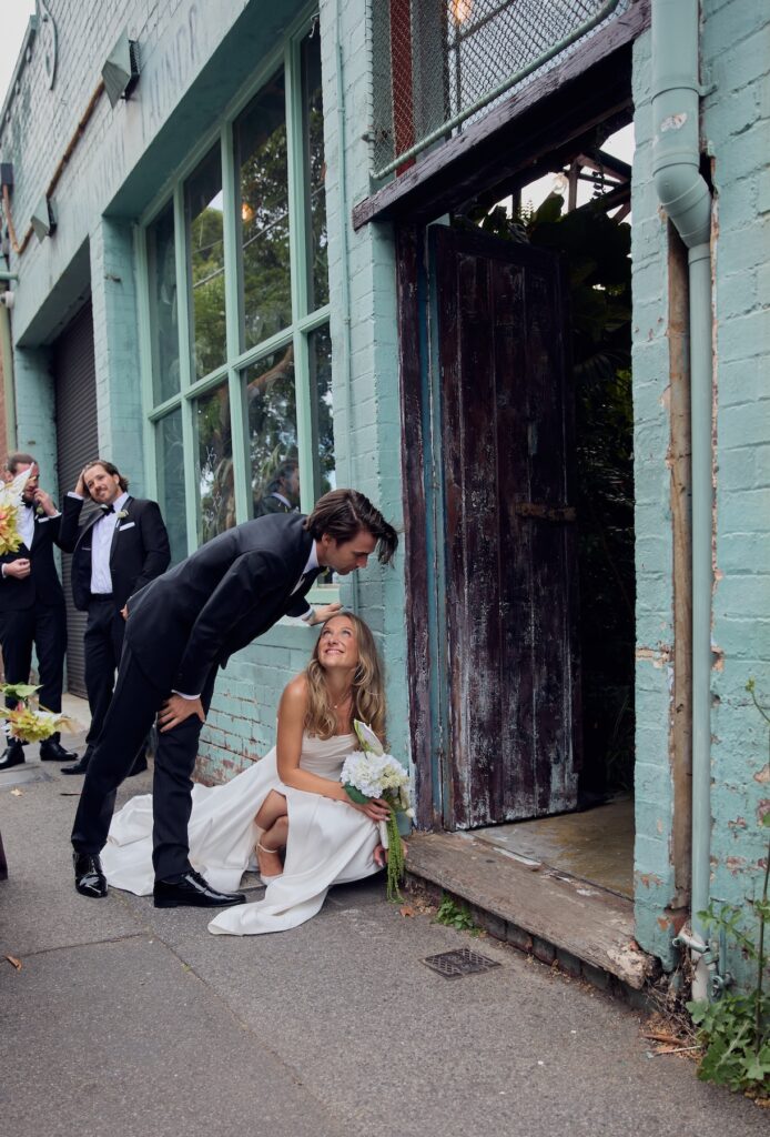 a bride crouches outside the Glasshaus wedding venue Melbourne