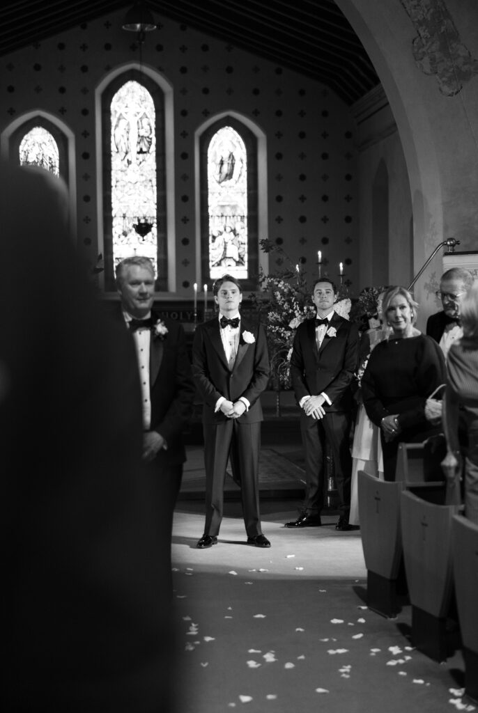A man waiting by the alter of a church on his wedding day